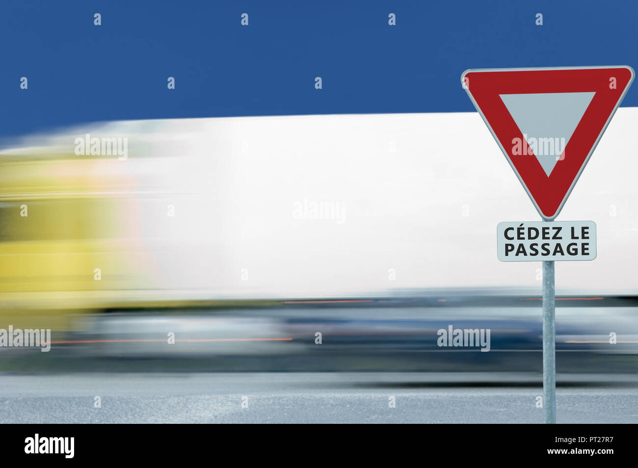 Rendement moyen donner cédez le passage français road sign, motion blurred camion trafic de véhicules, l'arrière-plan blanc triangle signalisation cadre rouge avertissement réglementaire Banque D'Images