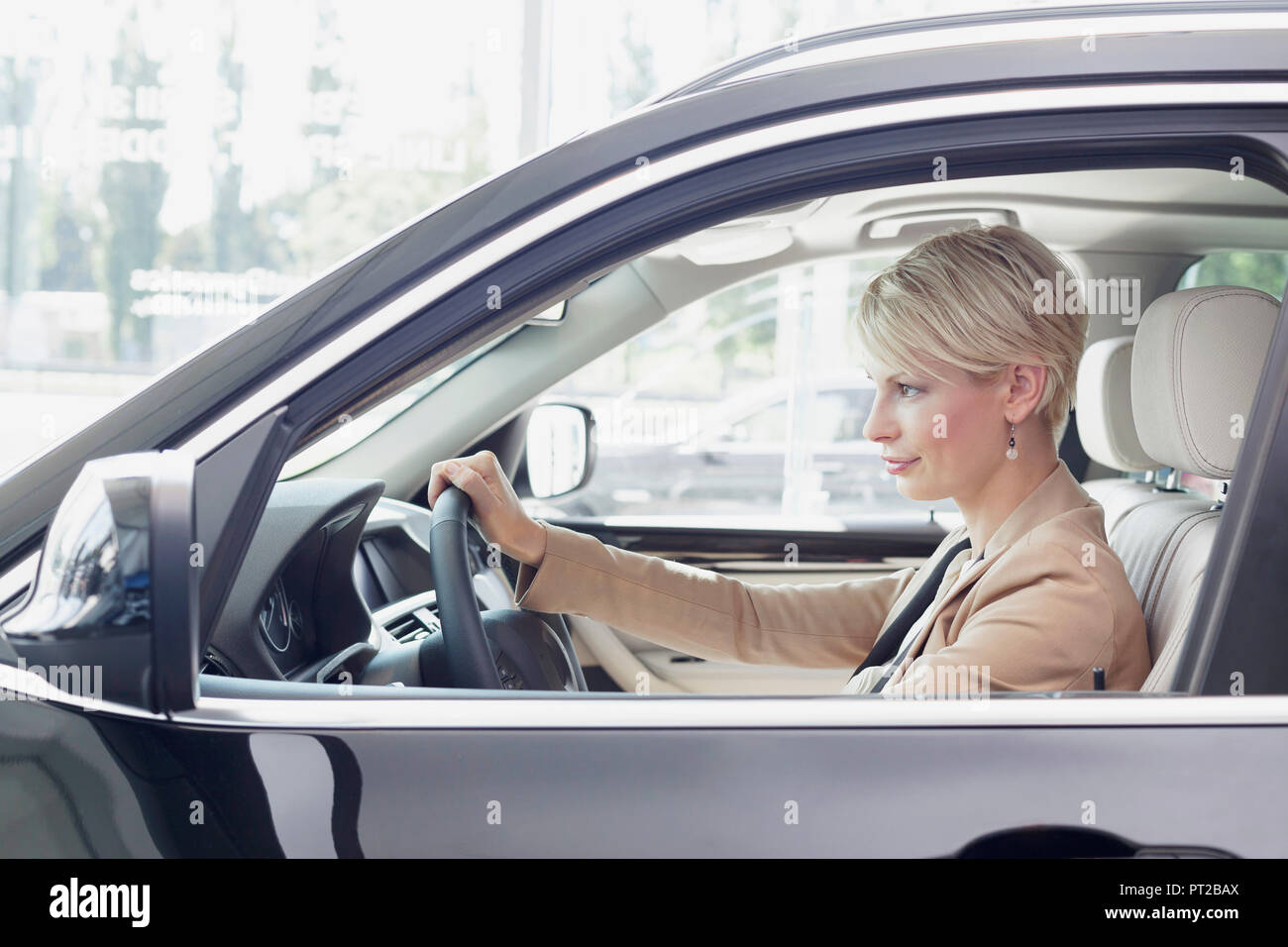 Au concessionnaire, Woman sitting in new car Banque D'Images