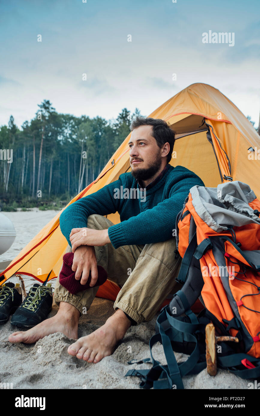 Backpacker assis devant sa tente sur la plage Banque D'Images