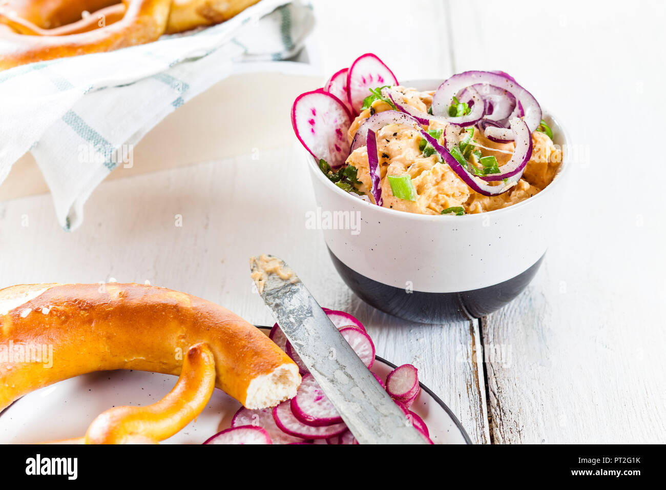 Obatzda avec oignon rouge, radis, oignon de printemps et bretzel Banque D'Images