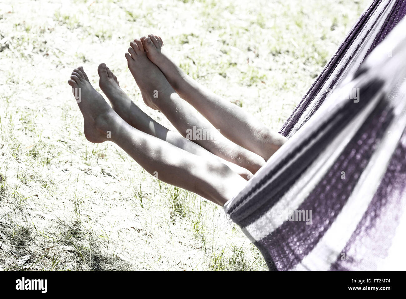 2 filles swing leurs jambes sur un hamac tout en basculant Banque D'Images