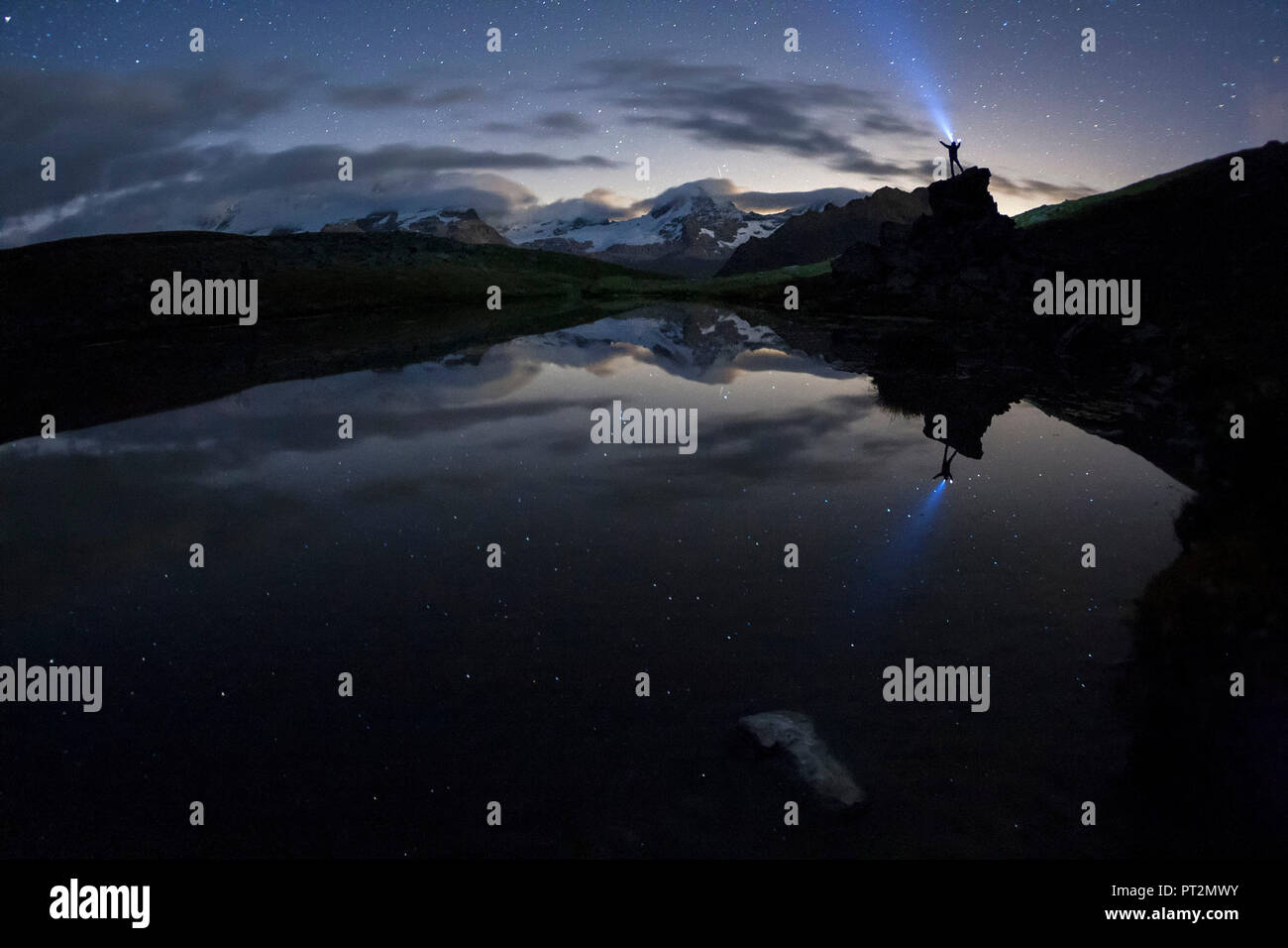 Randonneur avec le flambeau reflétée dans le petit lac du Pian Borgno, Valsavarenche, vallée d'aoste, Italie Banque D'Images
