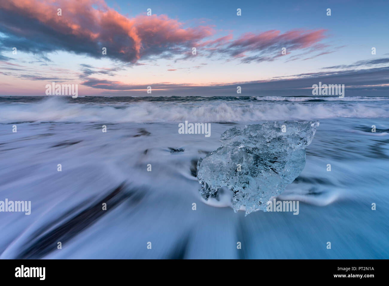 Petit bloc de glace sur la plage noire au coucher du soleil dans le lagon du Glacier Jökulsárlón, Austurland, l'Est de l'Islande, Islande, Europe Banque D'Images