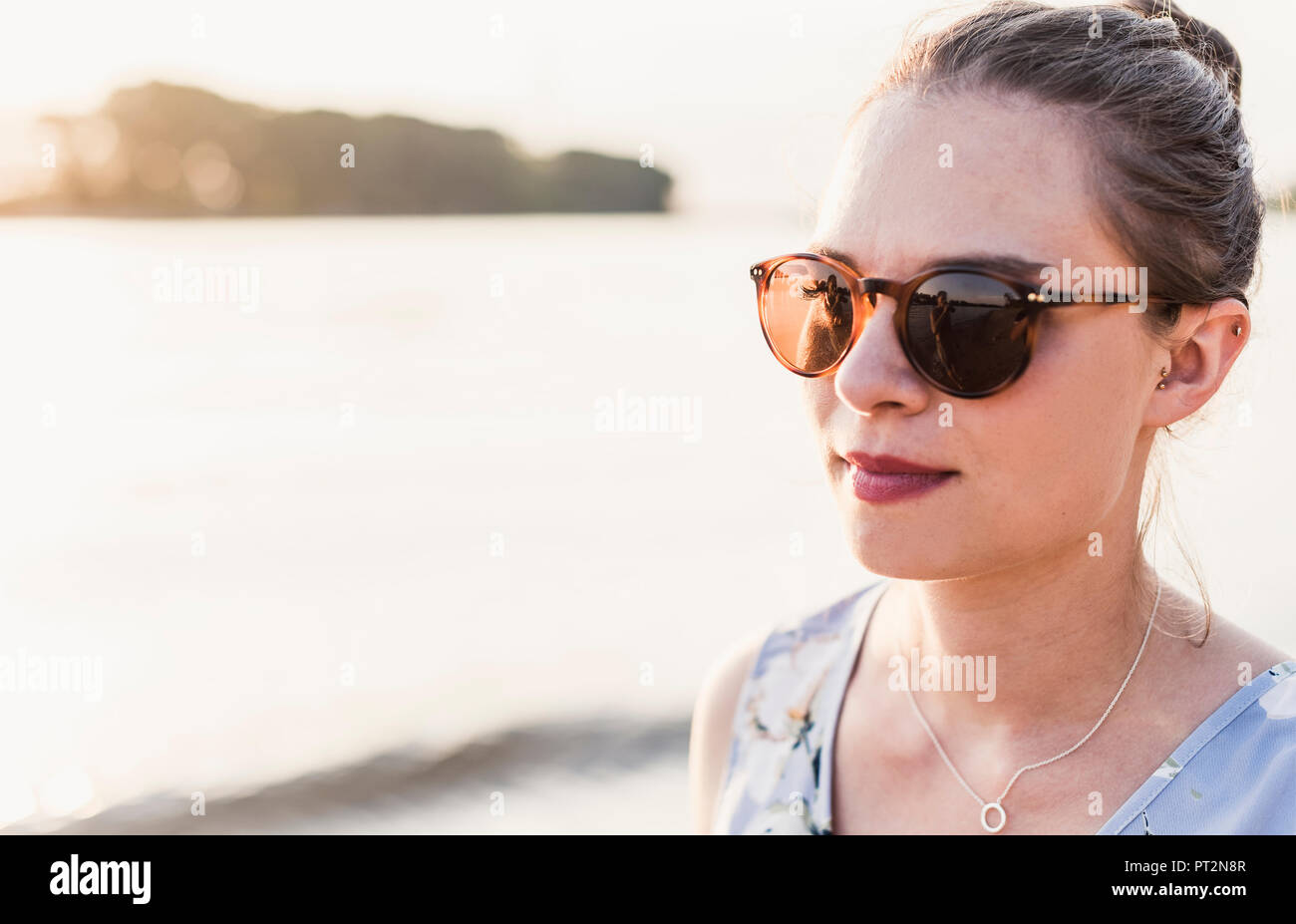 Jeune femme portant des lunettes de soleil à la rivière Banque D'Images