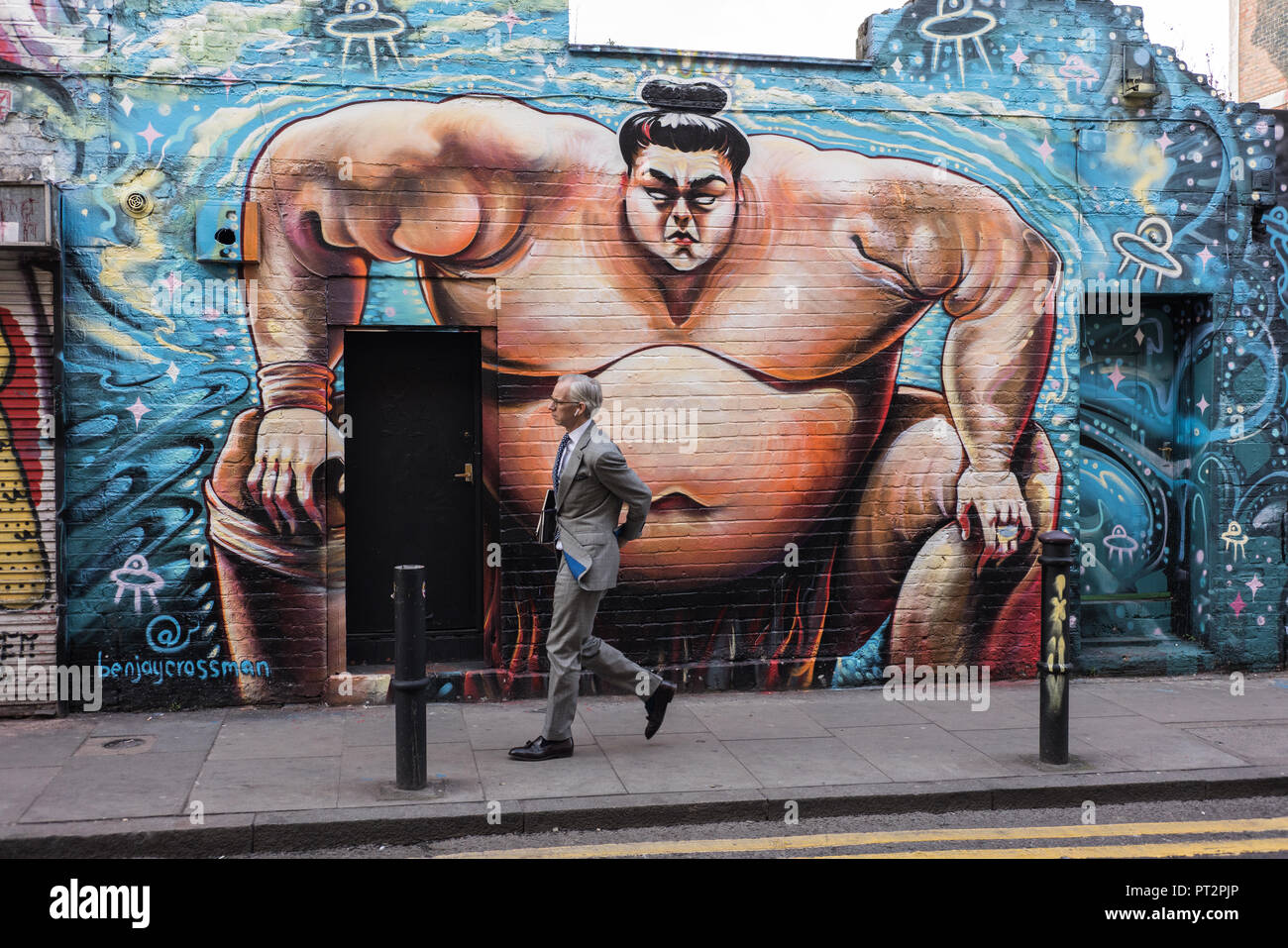 Lutteur de Sumo de l'écriture Graffiti est un excellent contexte pour tirer sur des passants dans Brick Lane, East London UK Banque D'Images Lutteur de Sumo de l'écriture Graffiti est un excellent contexte pour tirer sur des passants dans Brick Lane, East London UK Banque D'Images