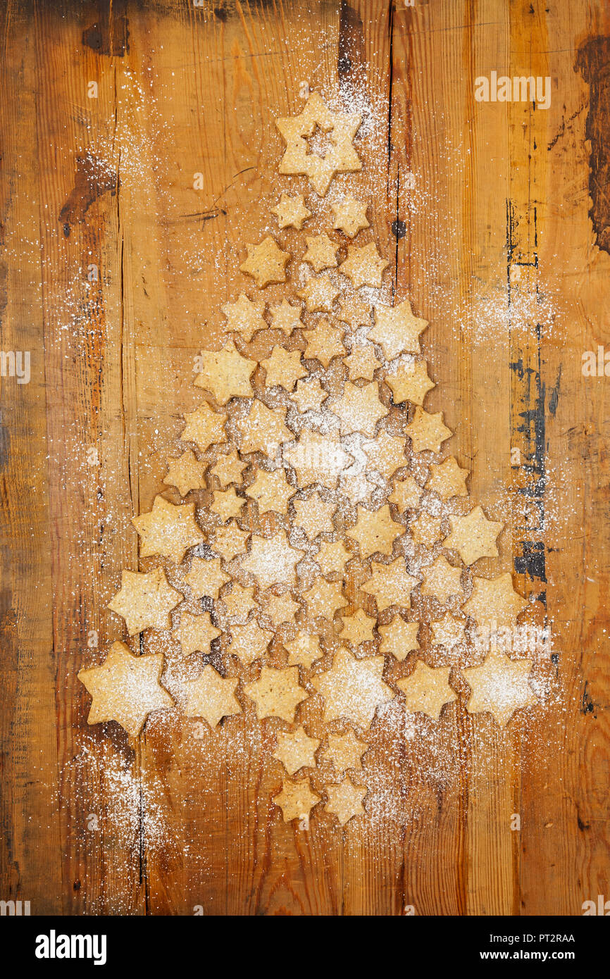 Des biscuits en forme d'étoiles formant Arbre de Noël sur fond de bois Banque D'Images