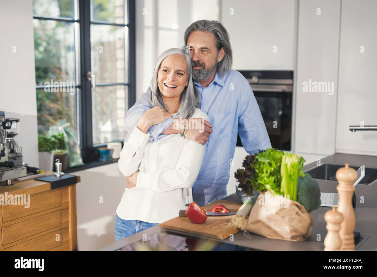 Happy senior couple preparing food in kitchen Banque D'Images