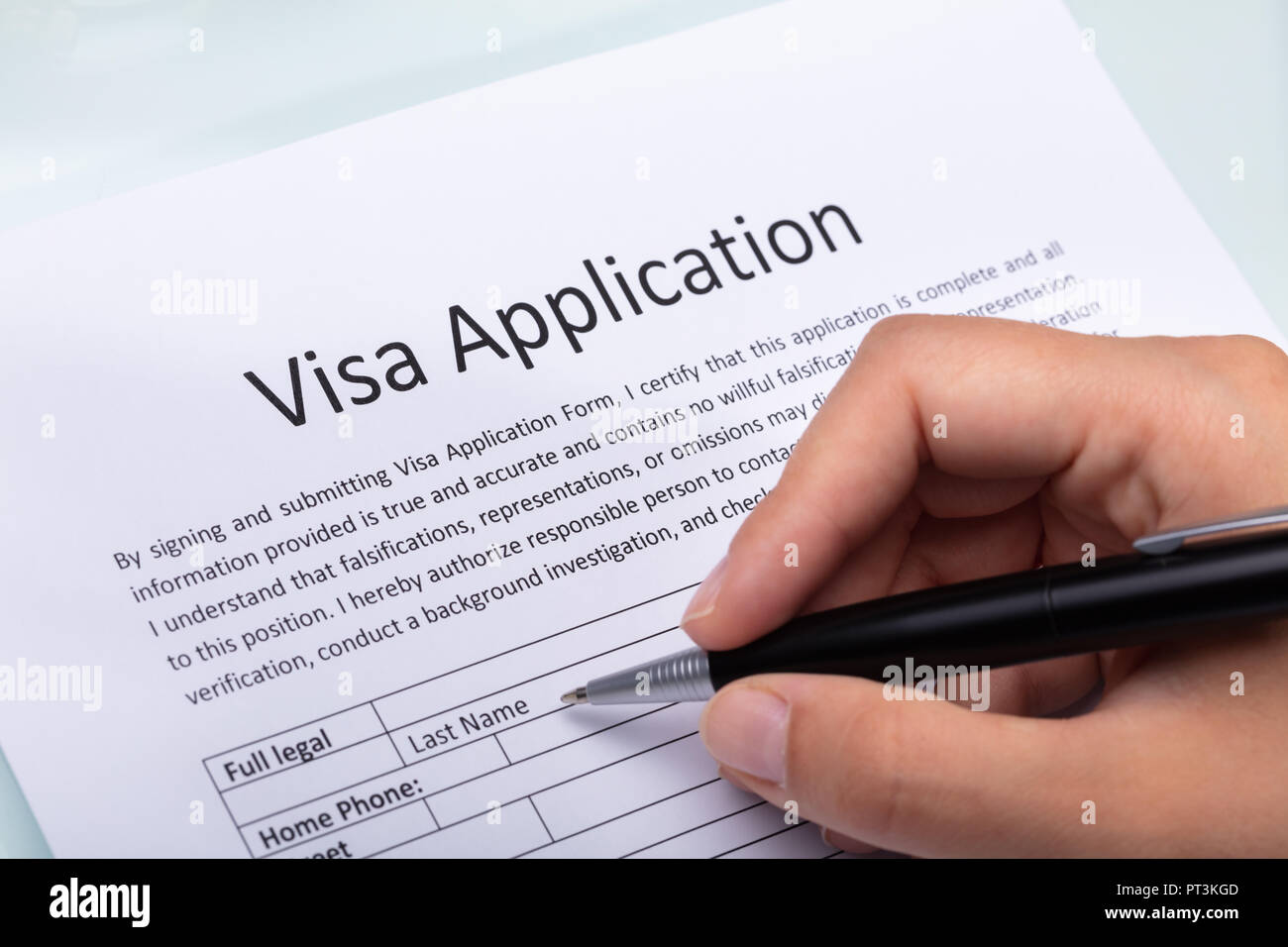 Close-up of a Woman's Hand remplir formulaire de demande de visa avec stylet Banque D'Images