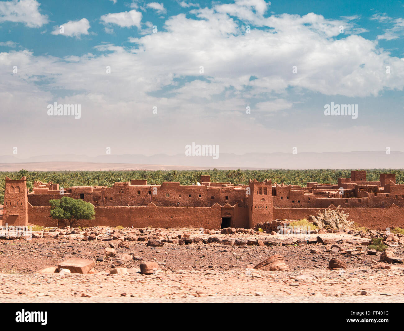 Village et Oasis dans la vallée du Draa, entre le sahara et l'Atlas, au Maroc. Ciel bleu et nuages en arrière-plan Banque D'Images