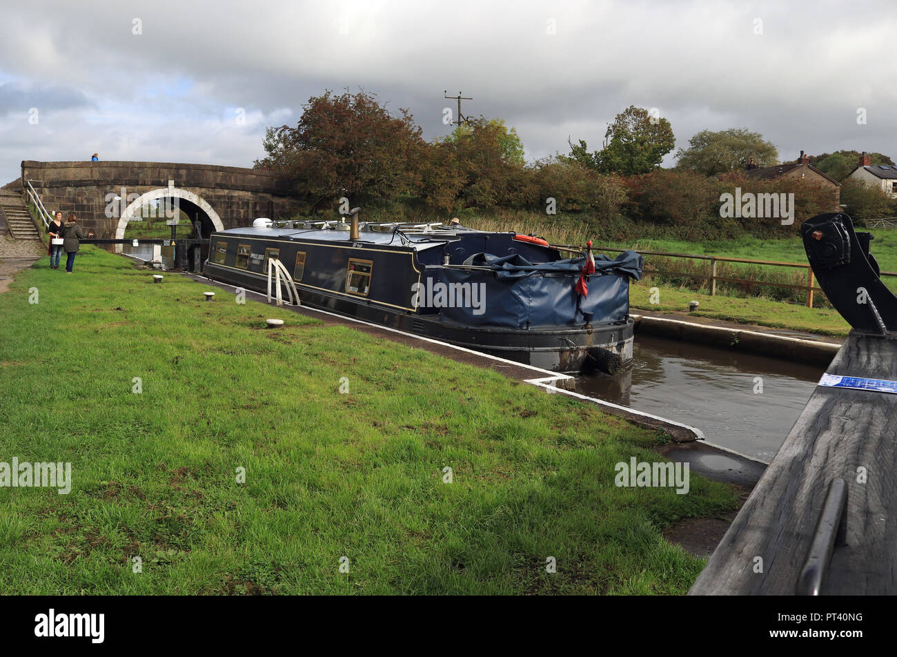 Après les pluies récentes partie de la Leeds et Liverpool donne l'occasion, un bateau fonctionne jusqu'les écluses de Johnsons Hill près de Chorley, dans le Lancashire. Banque D'Images