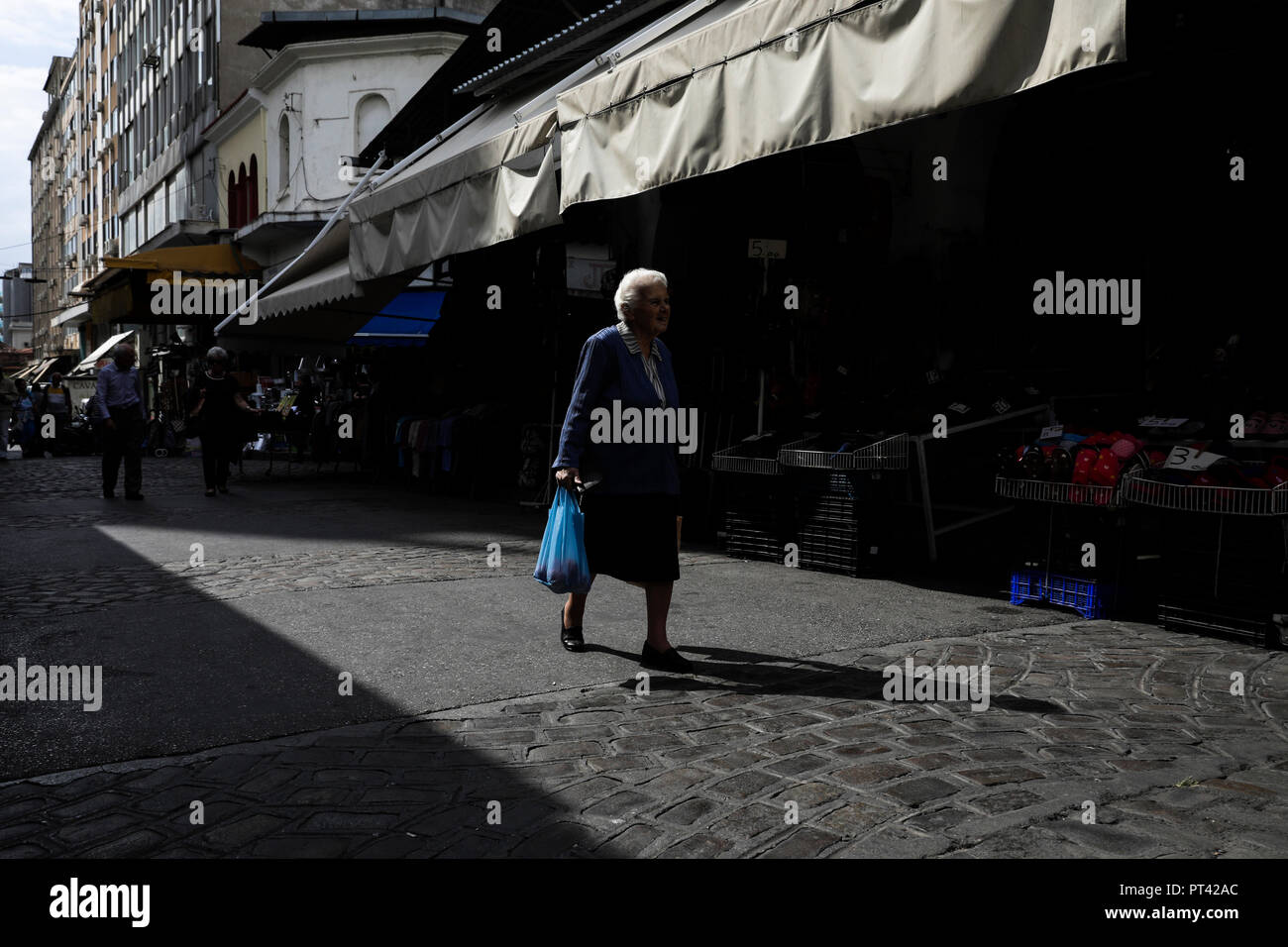 Une femme âgée est porteur d'un sac shopping en s'en allant au marché Kapani à Thessalonique, Grèce le 4 octobre 2018. Banque D'Images