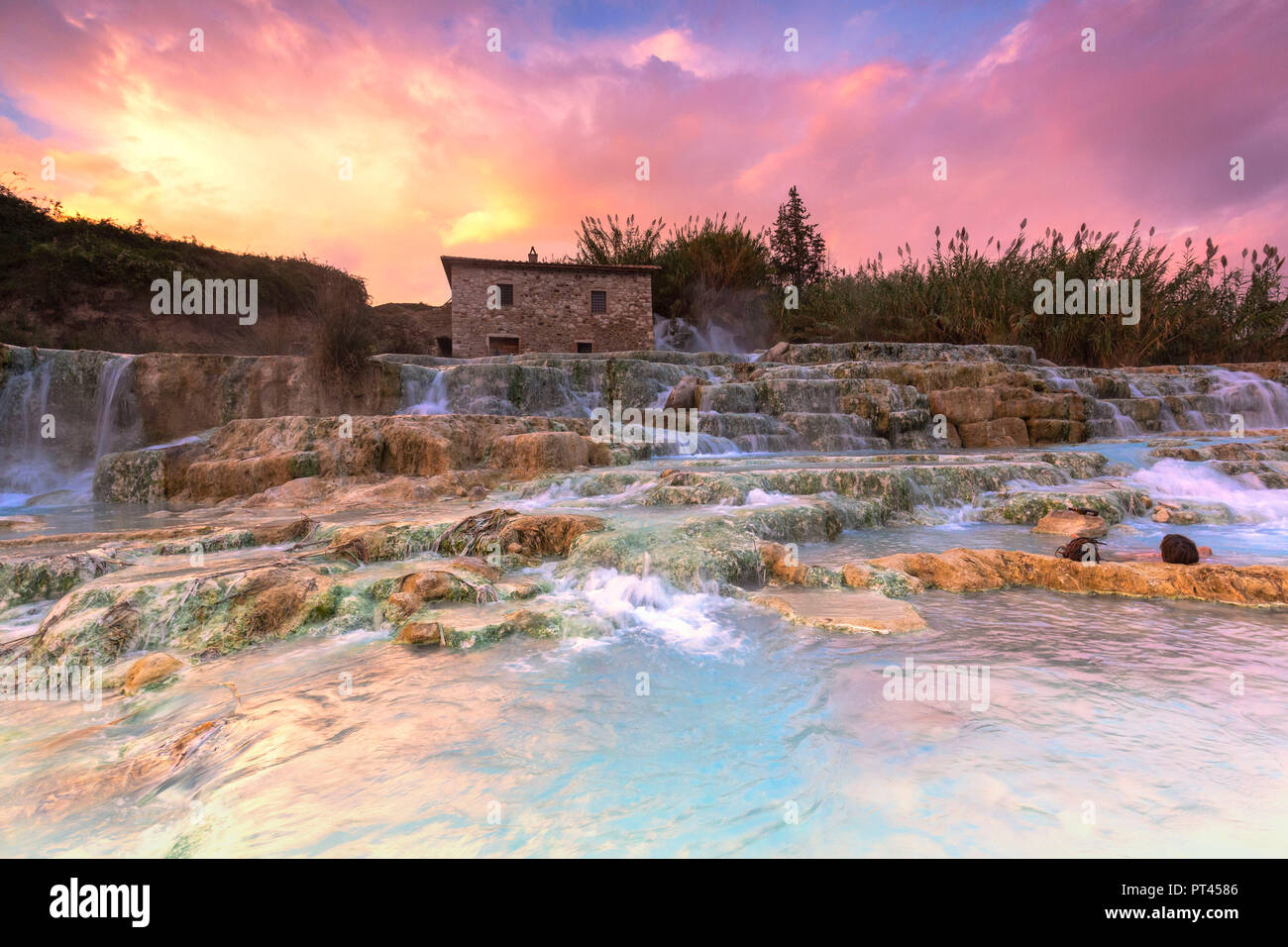 Les touristes se détendre pendant le coucher du soleil à termal Cascade Mill de Saturnia, Cascade Mill (Cascata del Mulino), Saturnia, Manciano, province de Grosseto, Toscane, Italie, Europe Banque D'Images