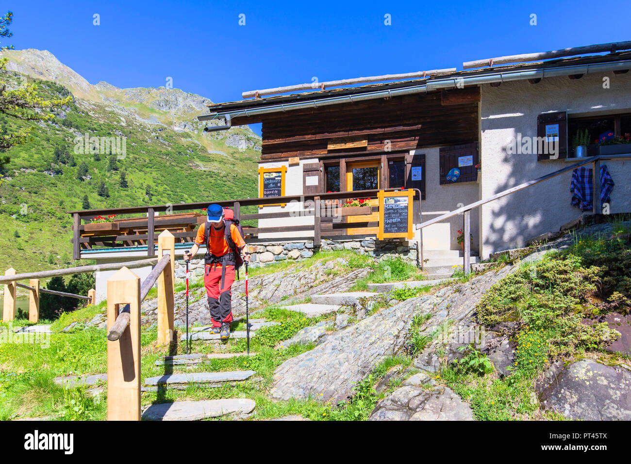 Randonneur descendre des escaliers à Cavloc Cavloccio Restaurant, Lake, Forno Vallée, Col Majola, Engadine, Grisons, Suisse, Europe, Banque D'Images