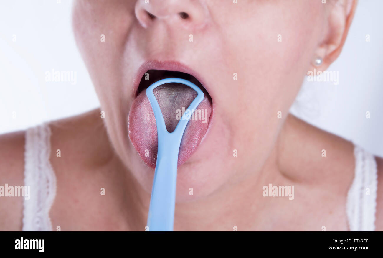 Gros plan du mature woman cleaning langue avec cleaner Banque D'Images