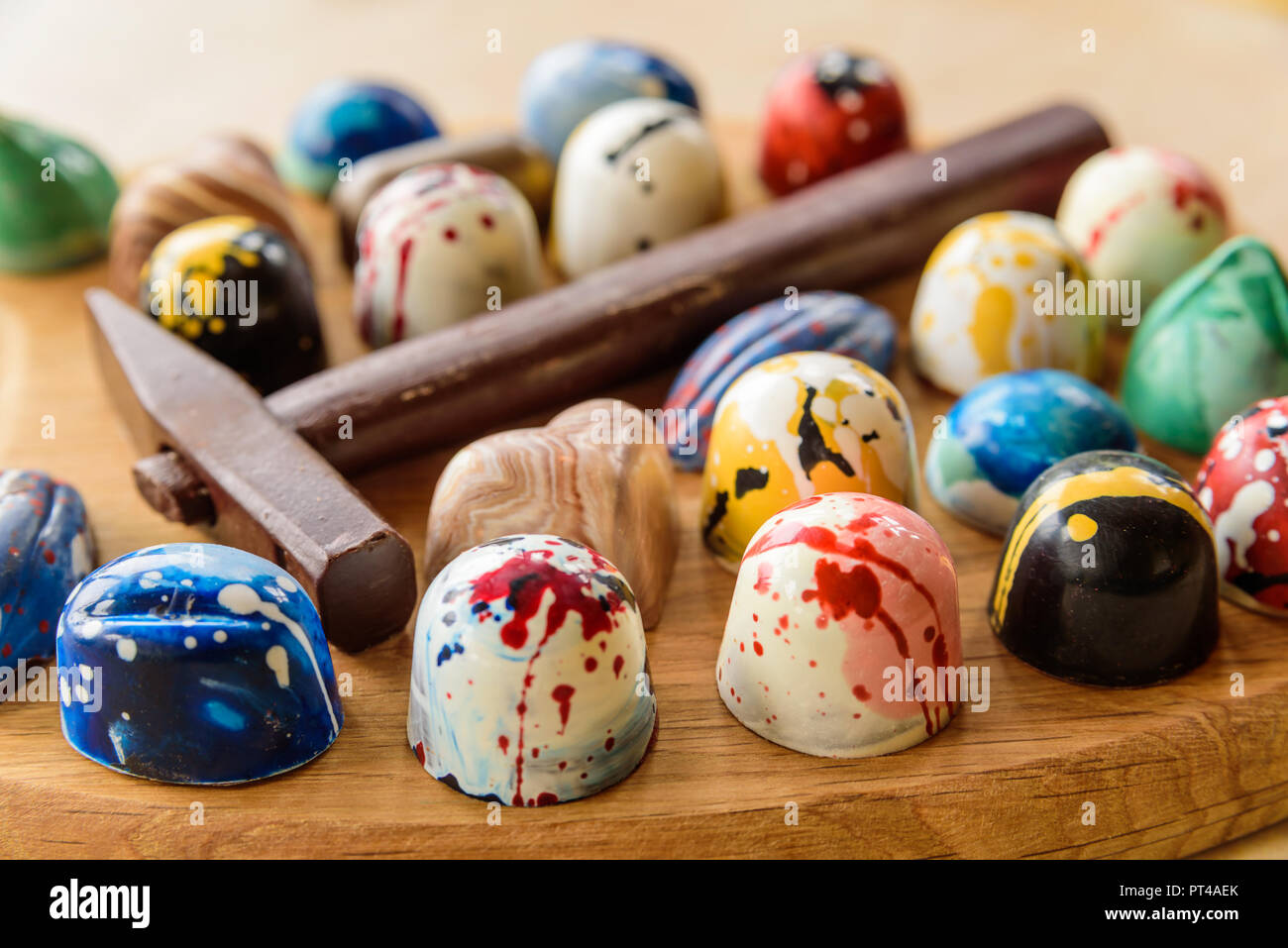 Assortiment de bonbons au chocolat maison et un marteau de chocolat sur un plateau en bois de chêne Banque D'Images
