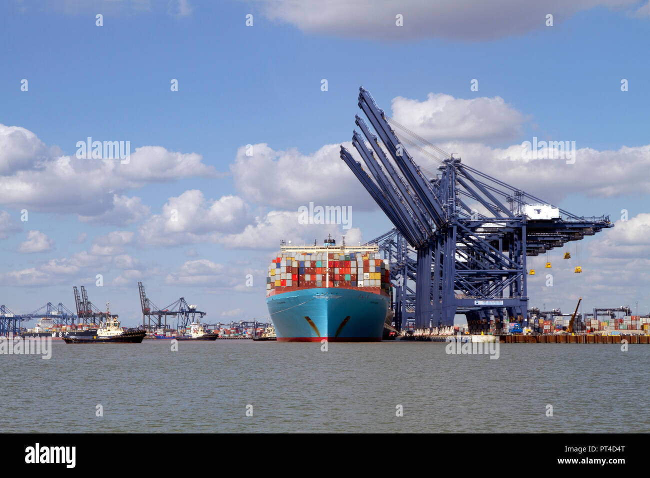 Un grand porte-conteneurs l'Eugen Maersk accostage à le port de Felixstowe étant assisté par deux remorqueurs. Banque D'Images