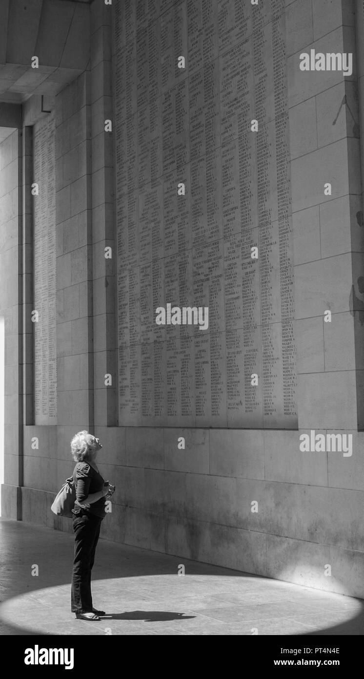 Dame à la recherche à certains des noms sur la porte de Menin memorial. Banque D'Images