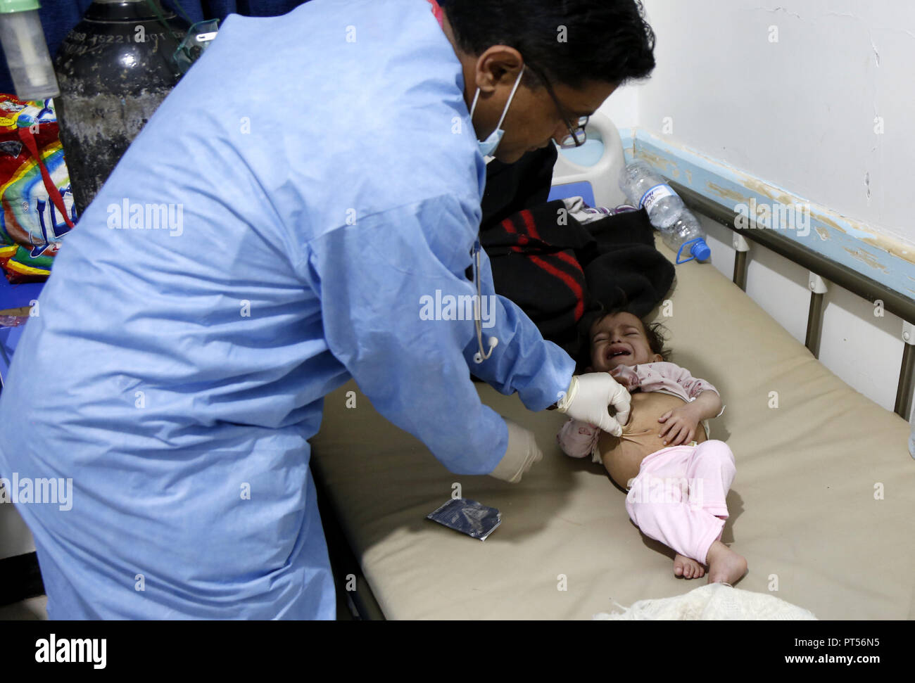 (181006) -- SANAA, le 6 octobre 2018 (Xinhua) -- un médecin examine un enfant infecté par le choléra à l'hôpital de Sanaa, Yémen, le 6 octobre 2018. Dans un centre de traitement du choléra au Yémen par les rebelles de la capitale, Sanaa, le samedi, presque tous les lits étaient occupés, avec plus de cas de choléra présumés arrivant à une vitesse alarmante. Selon l'Organisation mondiale de la santé, l'épidémie de choléra, qui a éclaté en avril 2017, a infecté 1,2 millions de personnes, 30  % sont des enfants, et 2 515 tués. Le porte-parole qui Tarik Jasarevic mis en garde contre une éventuelle nouvelle vague de l'épidémie en raison de la continui Banque D'Images