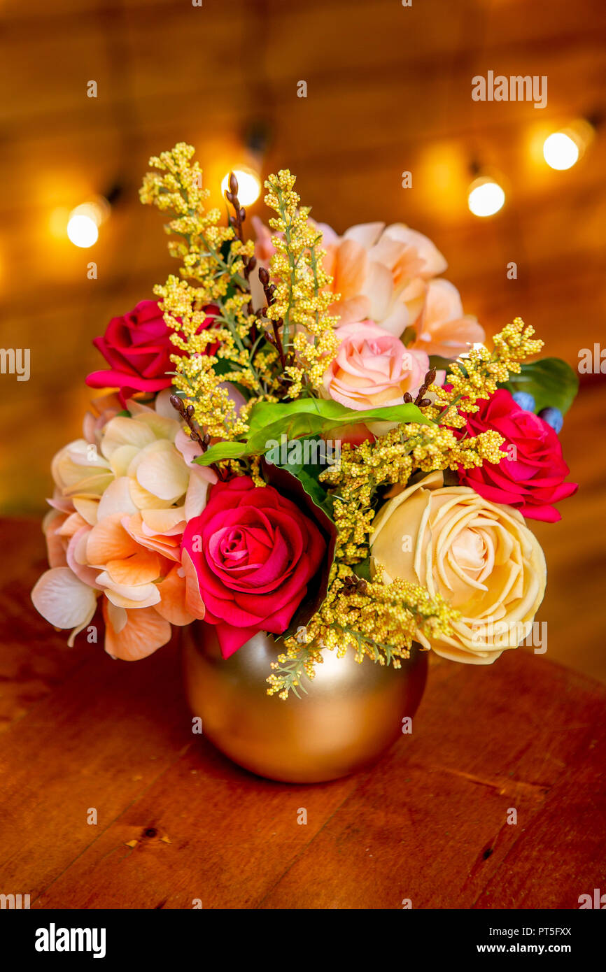 Arrangement de fleurs de roses, hortensia, forsythia et verdure dans un vase sur la table Banque D'Images