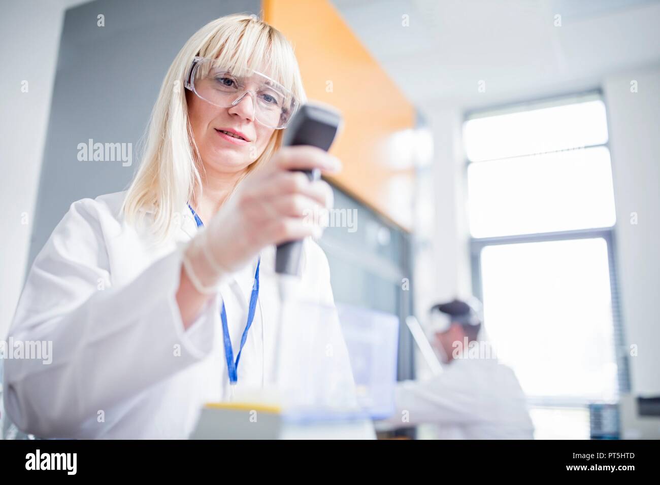 Female scientist portant des lunettes et l'utilisation de device. Banque D'Images