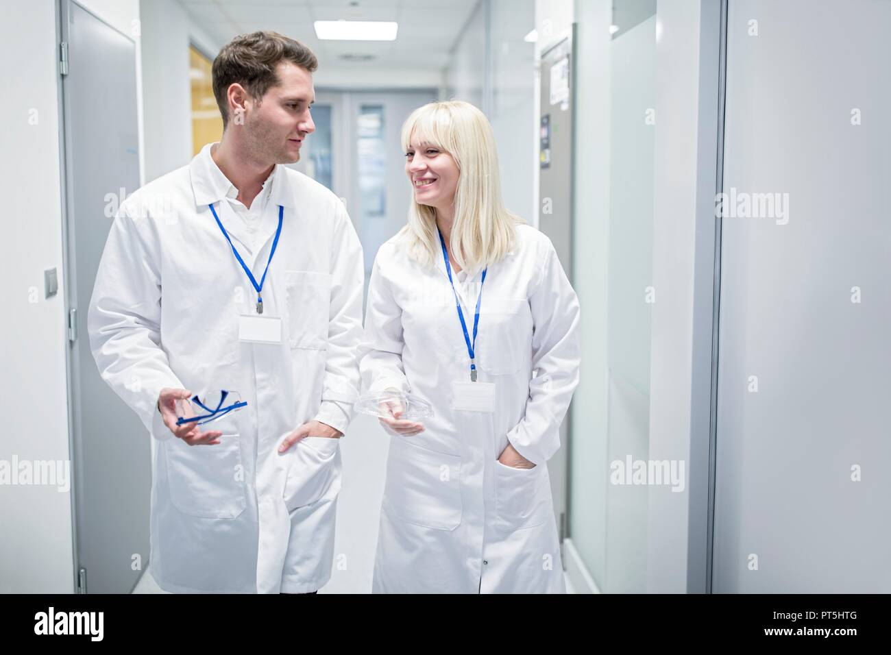 Les médecins hommes et femmes en blouse blanche walking down corridor. Banque D'Images