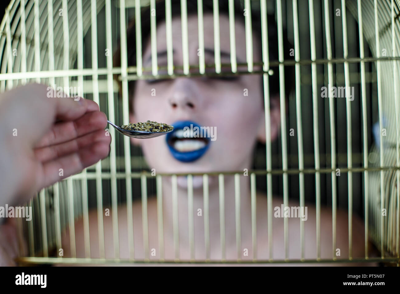 De conceptuel avec les lèvres bleues et cage à oiseaux sur la prise de tête du spoon Banque D'Images