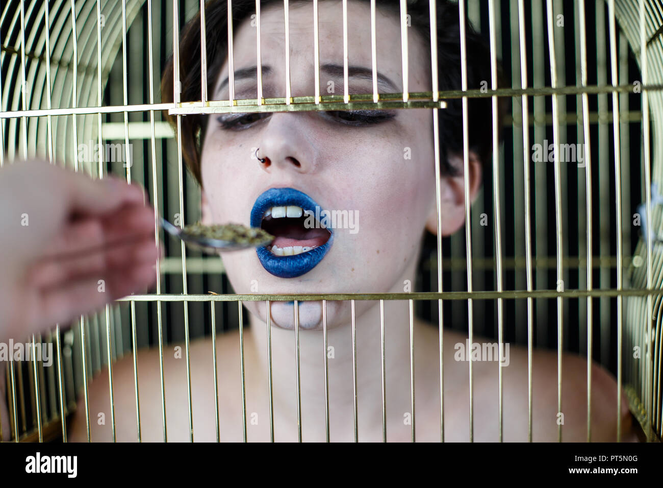 De conceptuel avec les lèvres bleues et cage à oiseaux sur la prise de tête du spoon Banque D'Images