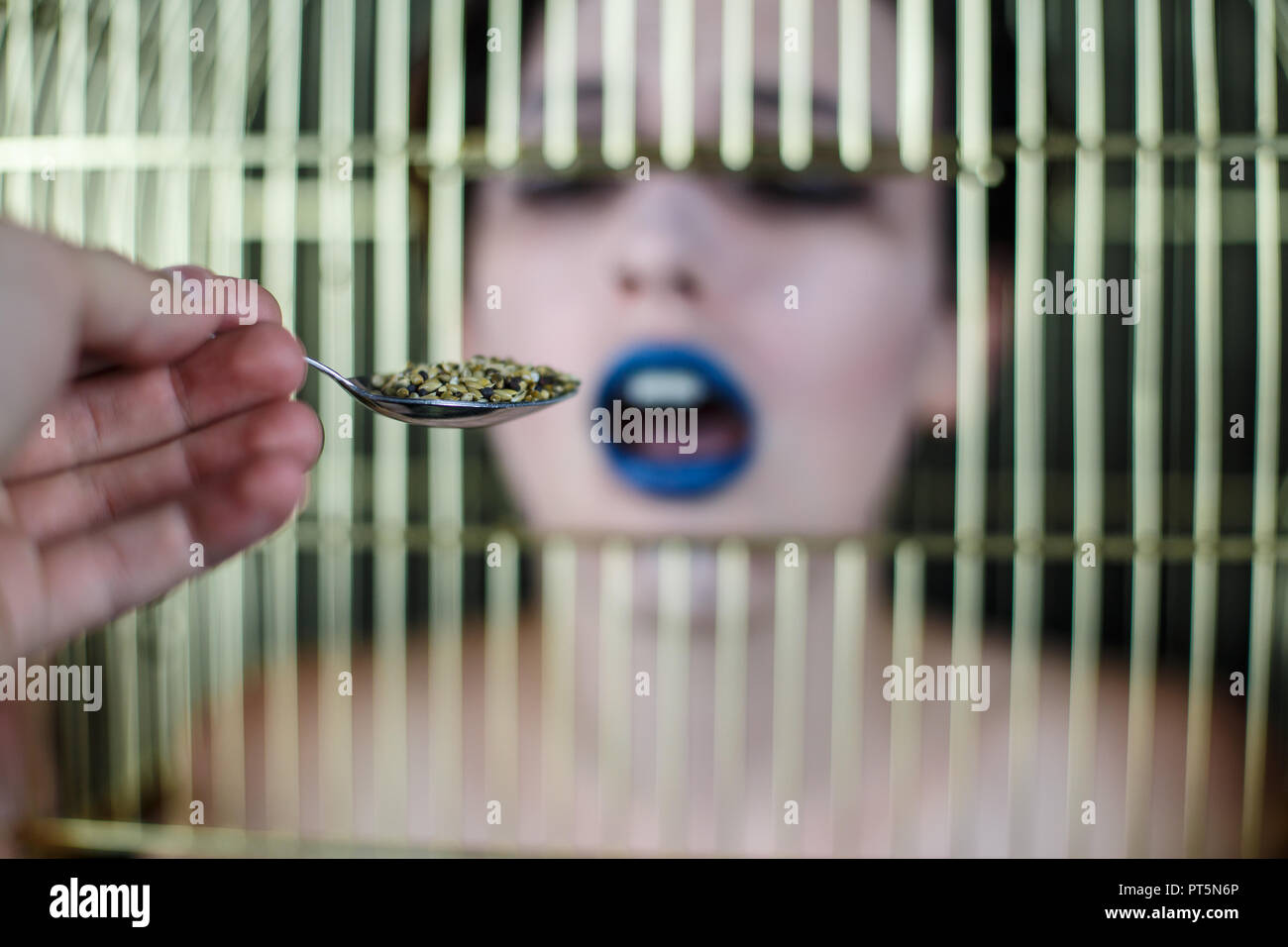 De conceptuel avec les lèvres bleues et cage à oiseaux sur la prise de tête du spoon Banque D'Images