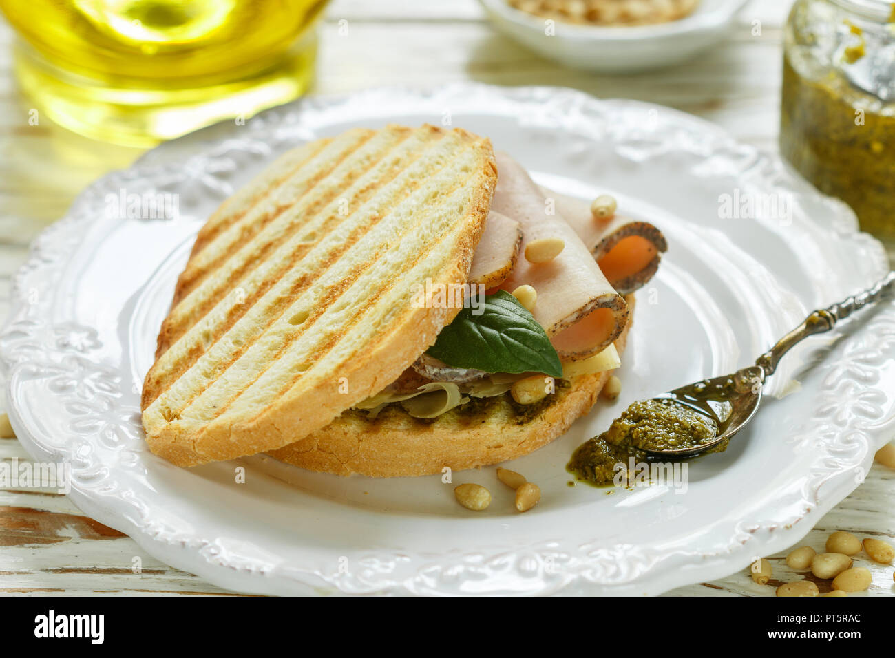 Délicieux sandwich avec jambon, fromage cuit au four, sauce pesto et pignons de pin. Collation santé pour les gourmets. Selective focus Banque D'Images