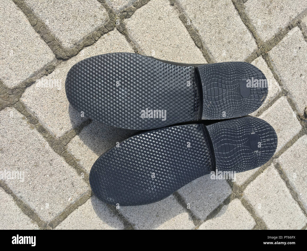 Nouvelle semelle de chaussure d'homme couché sur un trottoir Banque D'Images