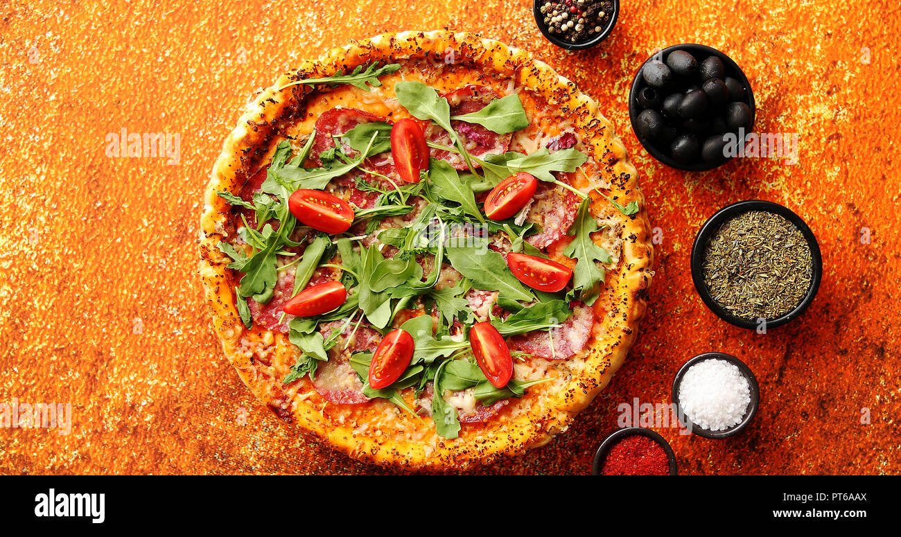 Pizza savoureuse sur un arrière-plan avec des épices, herbes et légumes Banque D'Images