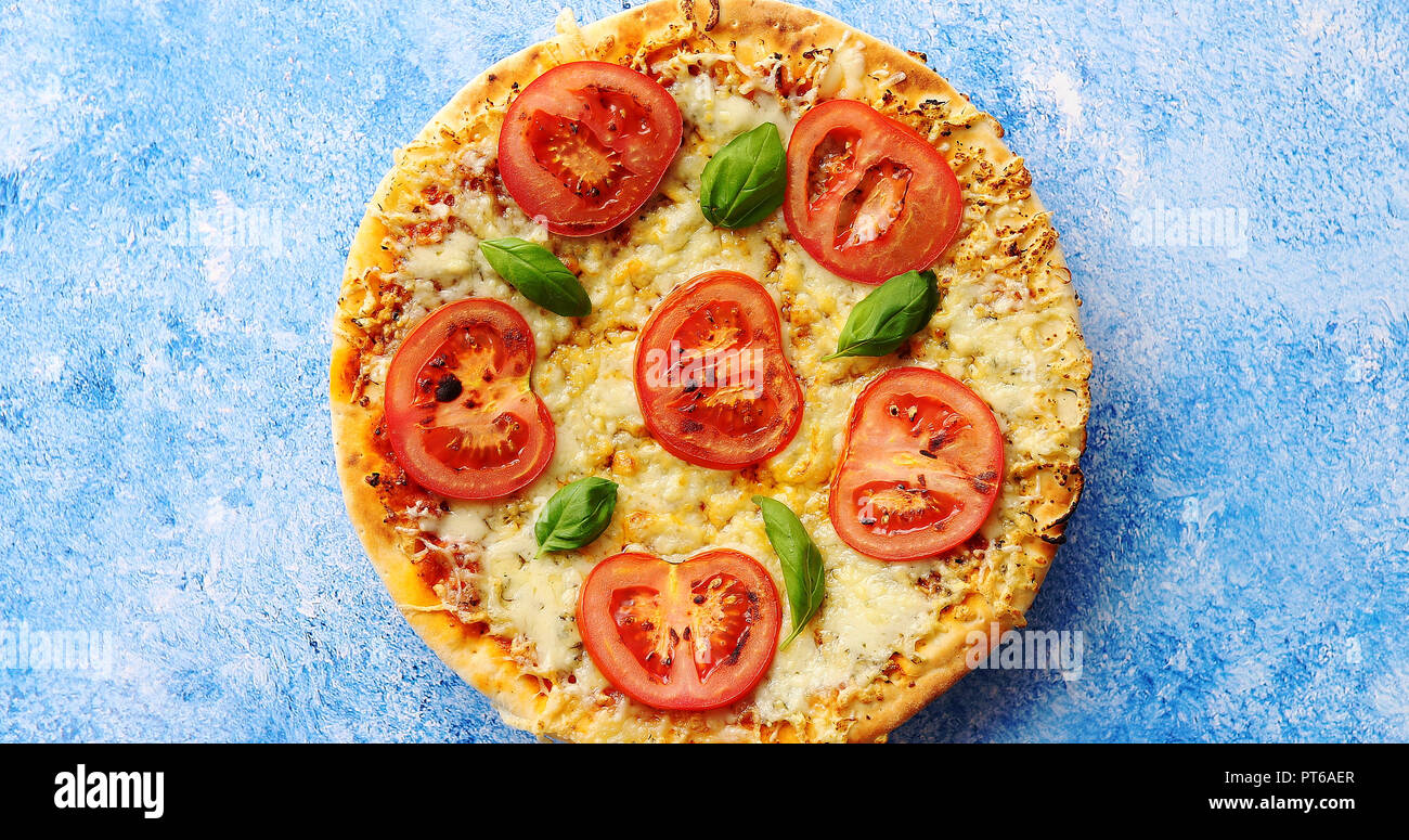 Pizza au fromage et tomates sur table en pierre bleue Banque D'Images