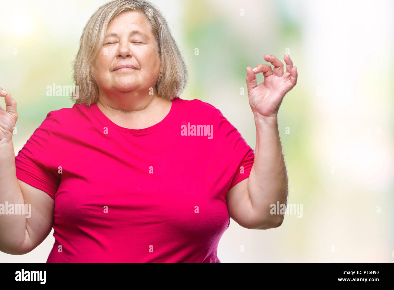 Grande taille Senior caucasian woman sur fond isolé vous détendre et souriant avec les yeux fermé faisant le geste de la méditation avec les doigts. Concept de yoga. Banque D'Images