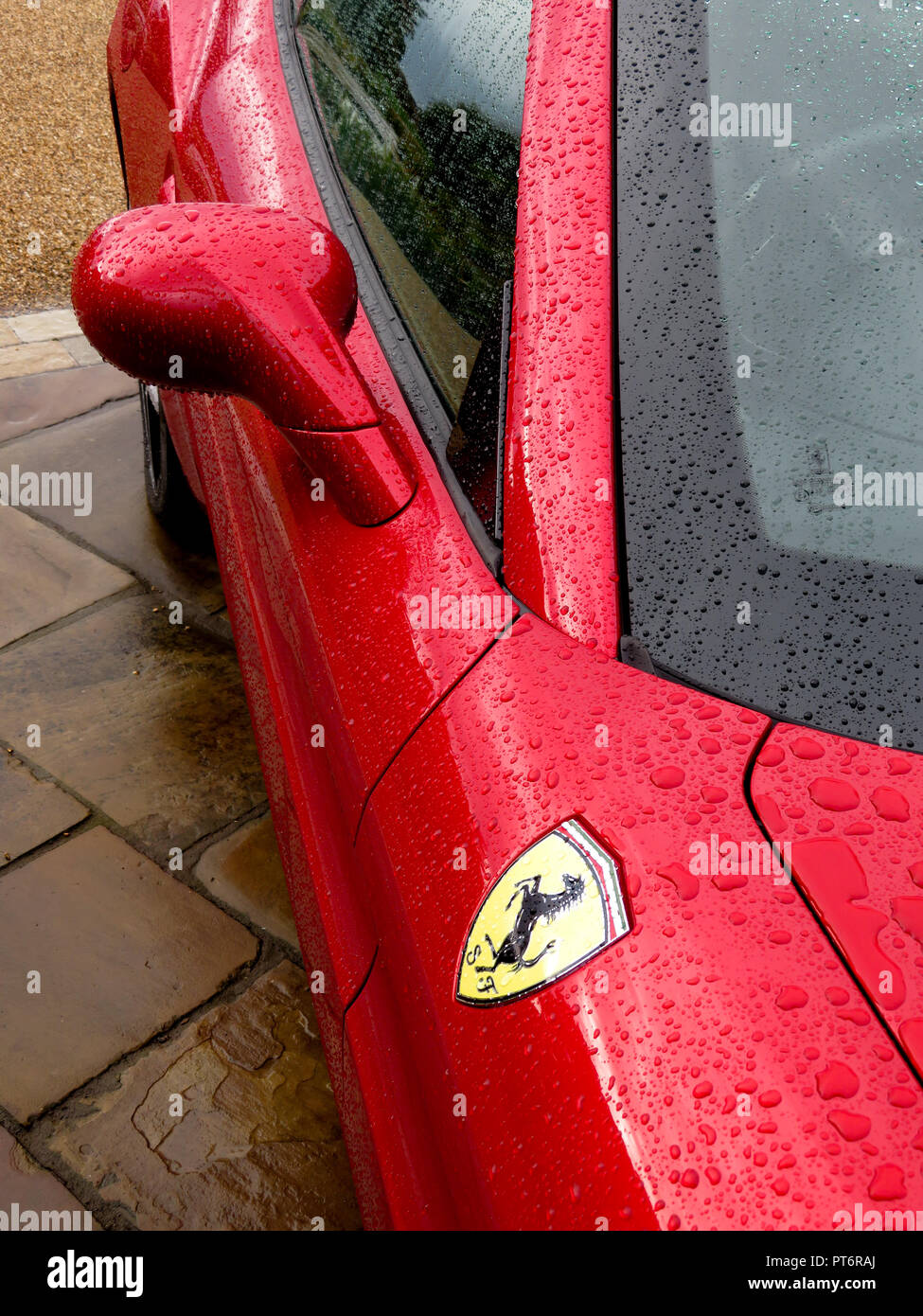 Le rétroviseur et le logo Ferrari sous la pluie montrant une carrosserie d'au-dessus Banque D'Images