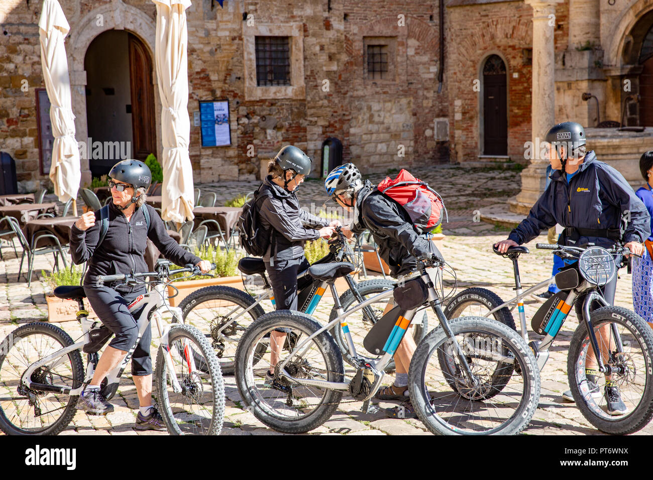 Groupe de cycle sur leur bicyclette se préparer à quitter la ville de Montepulciano colline toscane pour un tour à vélo,Toscane,Italie Banque D'Images