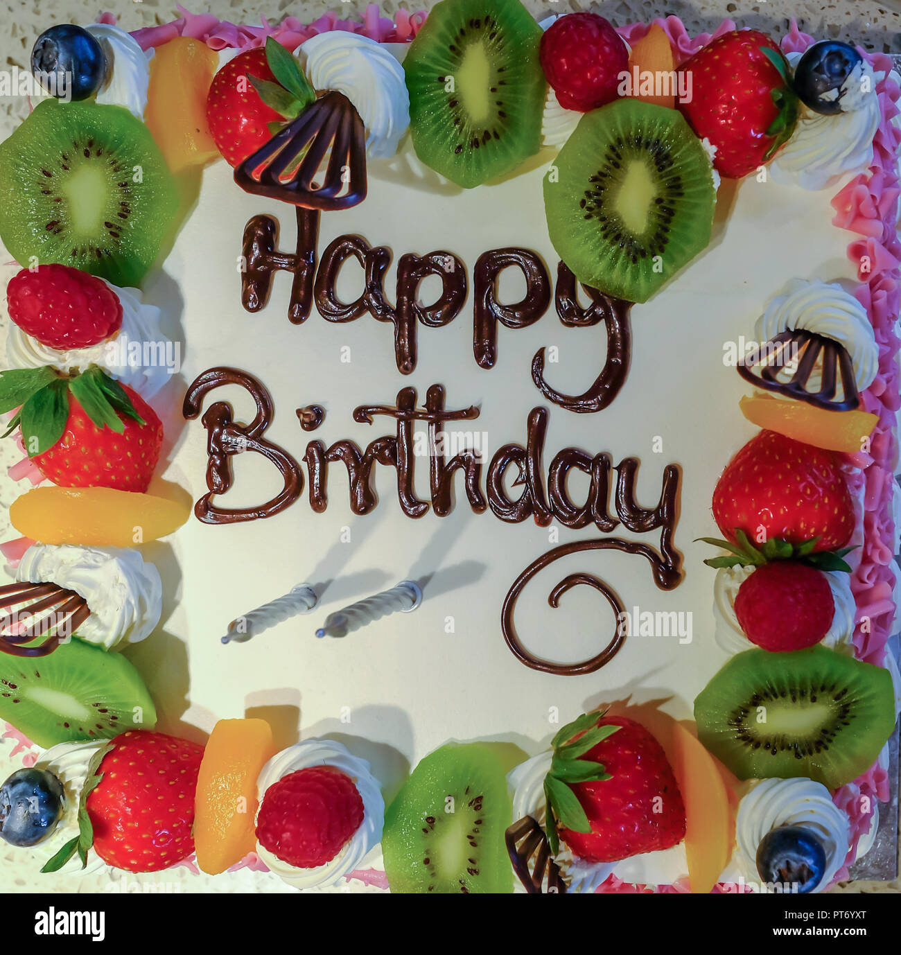 Gros Plan Du Visage Sur Avis D Une Creme Et Friuit Gateau D Anniversaire Cliche Pris Regardez Directement En Haut Du Gateau Et Montre Deux Bougies Et La Wo Photo Stock Alamy