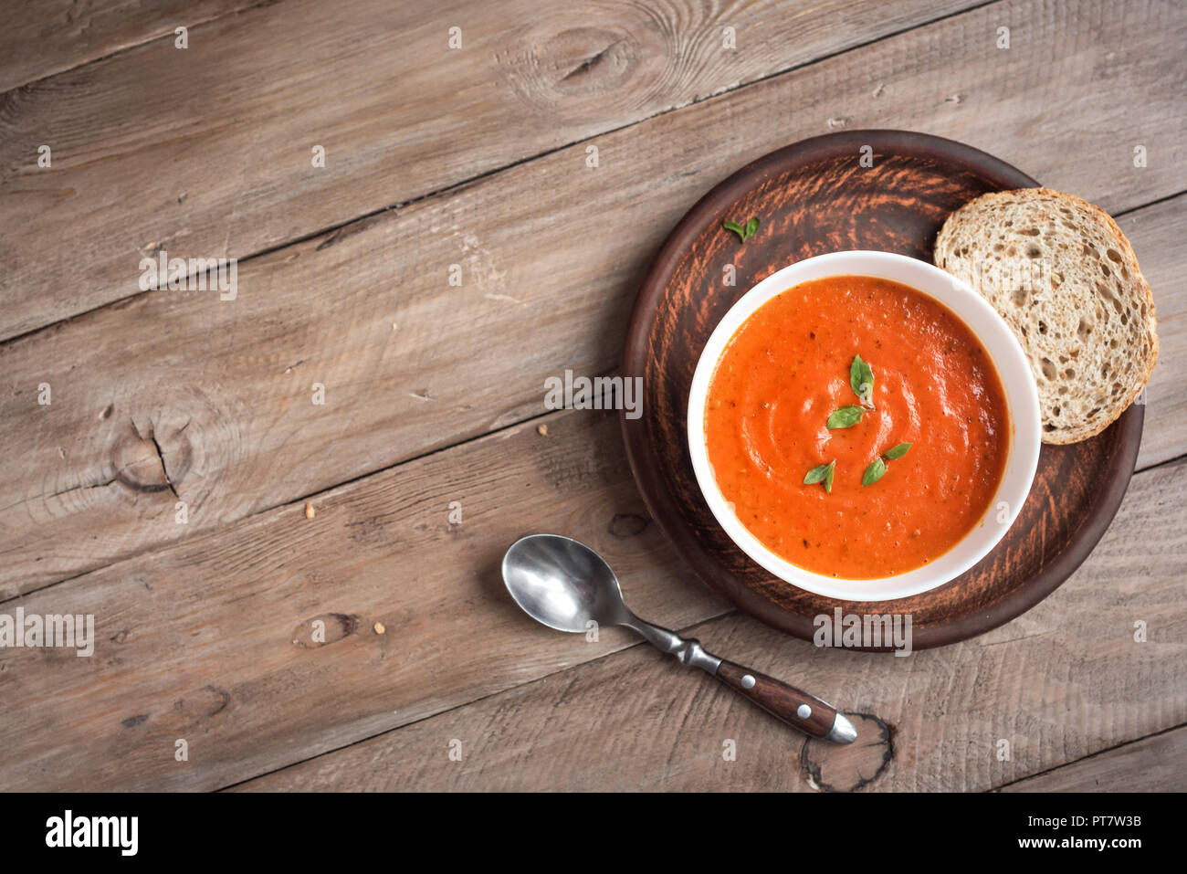 Soupe de tomate sur la table en bois, vue du dessus, copiez l'espace. Soupe aux tomates maison dans un bol. Banque D'Images