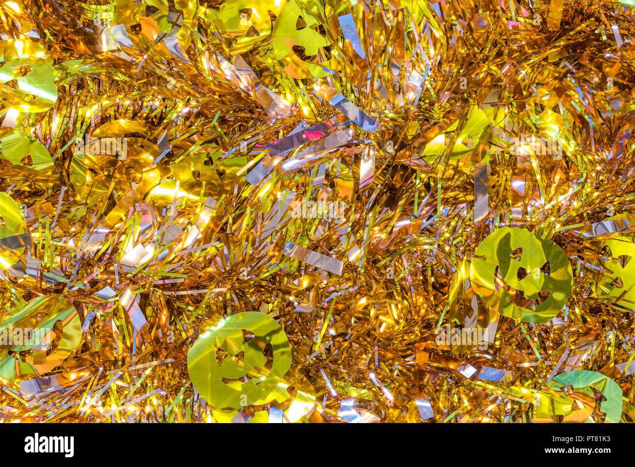La texture de fond plein de guirlandes d'or décoré de funny jack-o'-lantern pumpkin head décorations pour célébrer l'halloween. Banque D'Images