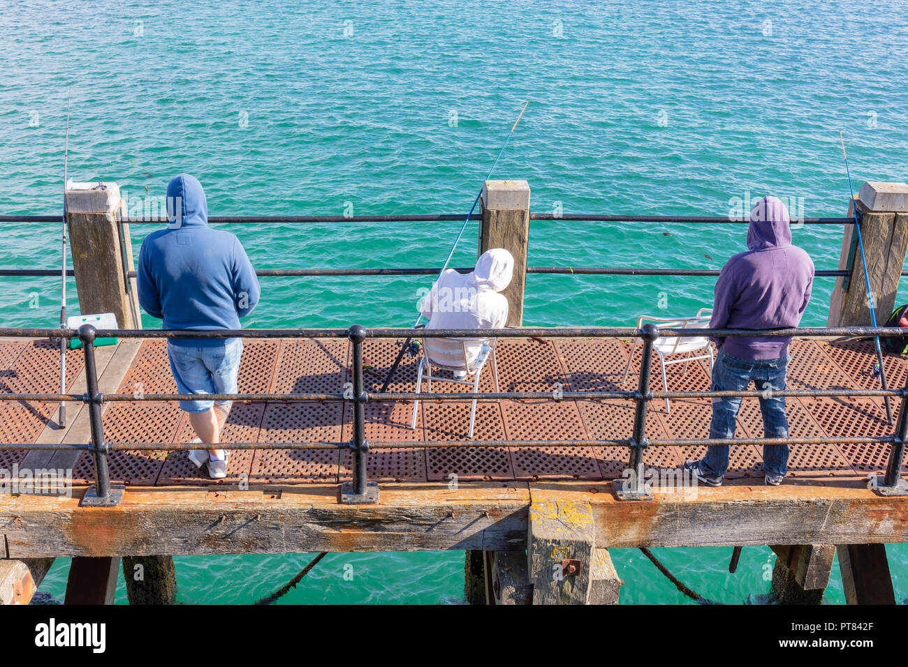 Vue arrière de trois hommes sur une passerelle de la pêche dans la mer. Banque D'Images