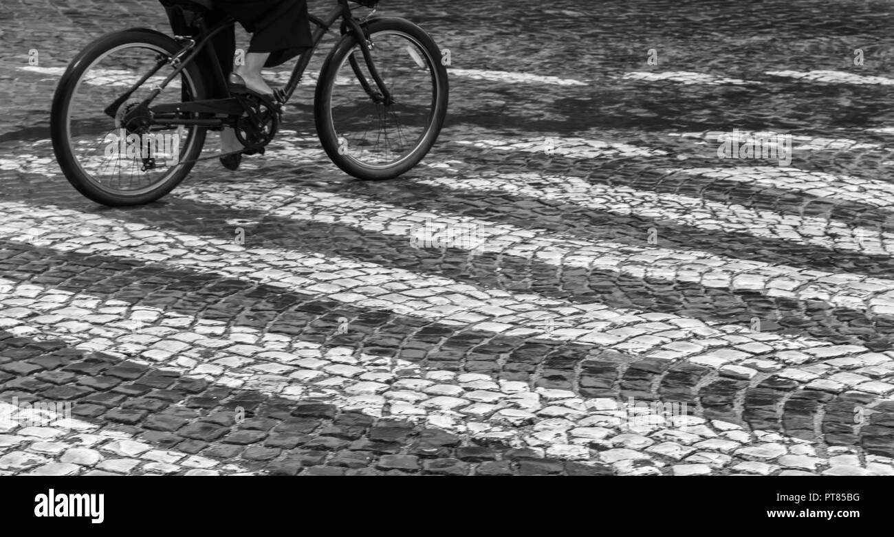 Une femme est conduite sous la pluie sur un vélo sur le sentier piétonnier Banque D'Images