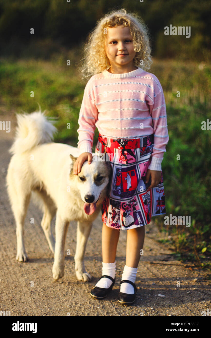 Petite fille blonde frisée et grand chien Banque D'Images