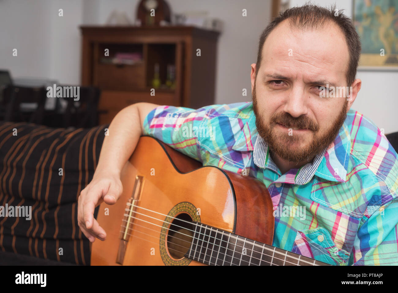 Jeune homme musicien jouant de la guitare acoustique Banque D'Images