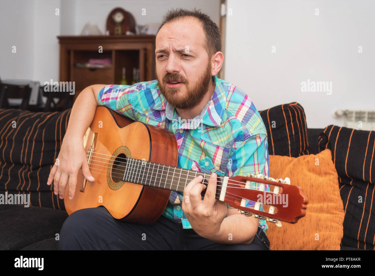 Jeune homme musicien jouant de la guitare acoustique Banque D'Images