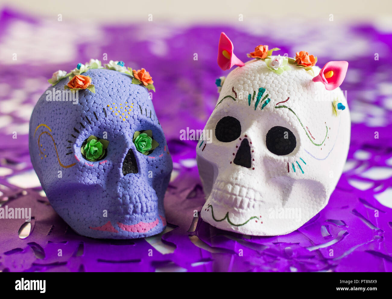 Le pourpre et le sucre blanc, crânes, le Jour des morts autel avec Purple papel picado (coupe papier de soie) comme décoration. Banque D'Images