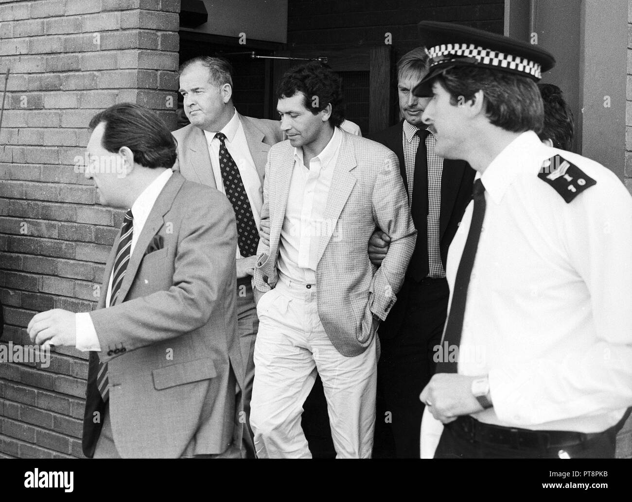 Fugitif britannique John Palmer est escorté jusqu'à l'aéroport Heathrow de Londres en 1986. Banque D'Images