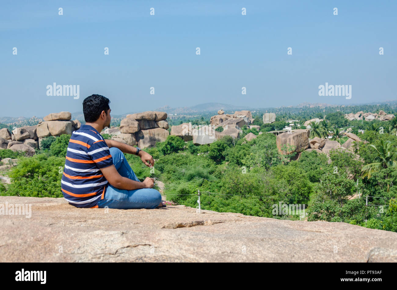 Jeune Indien assis sur Hemakuta Hill, en admirant la vue magnifique à Hampi, Karnataka, Inde Banque D'Images