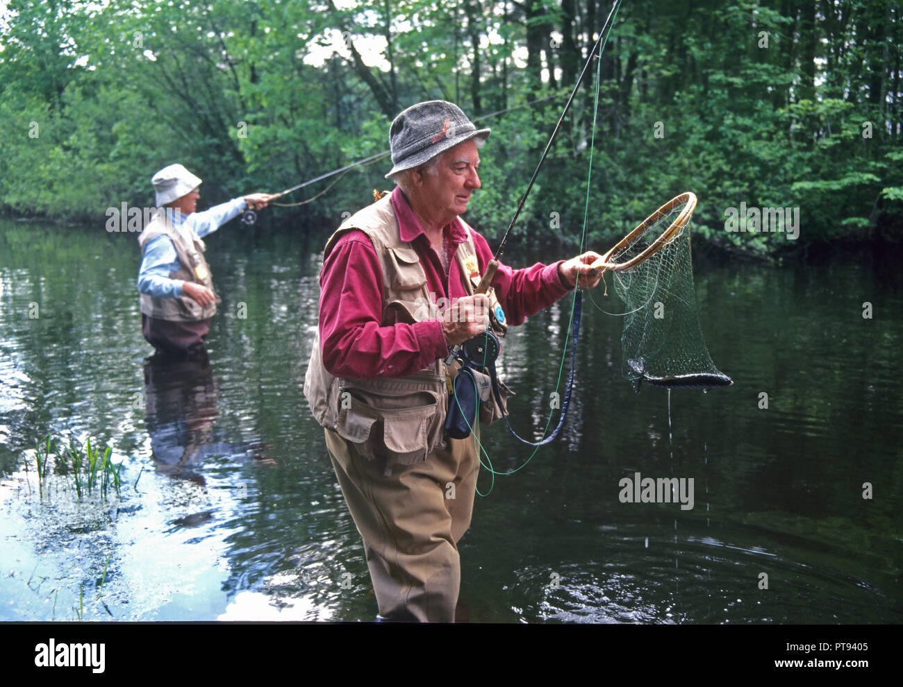Deux personnes âgées la pêche à la mouche dans une rivière dans le Massachusetts, Etats-Unis Banque D'Images