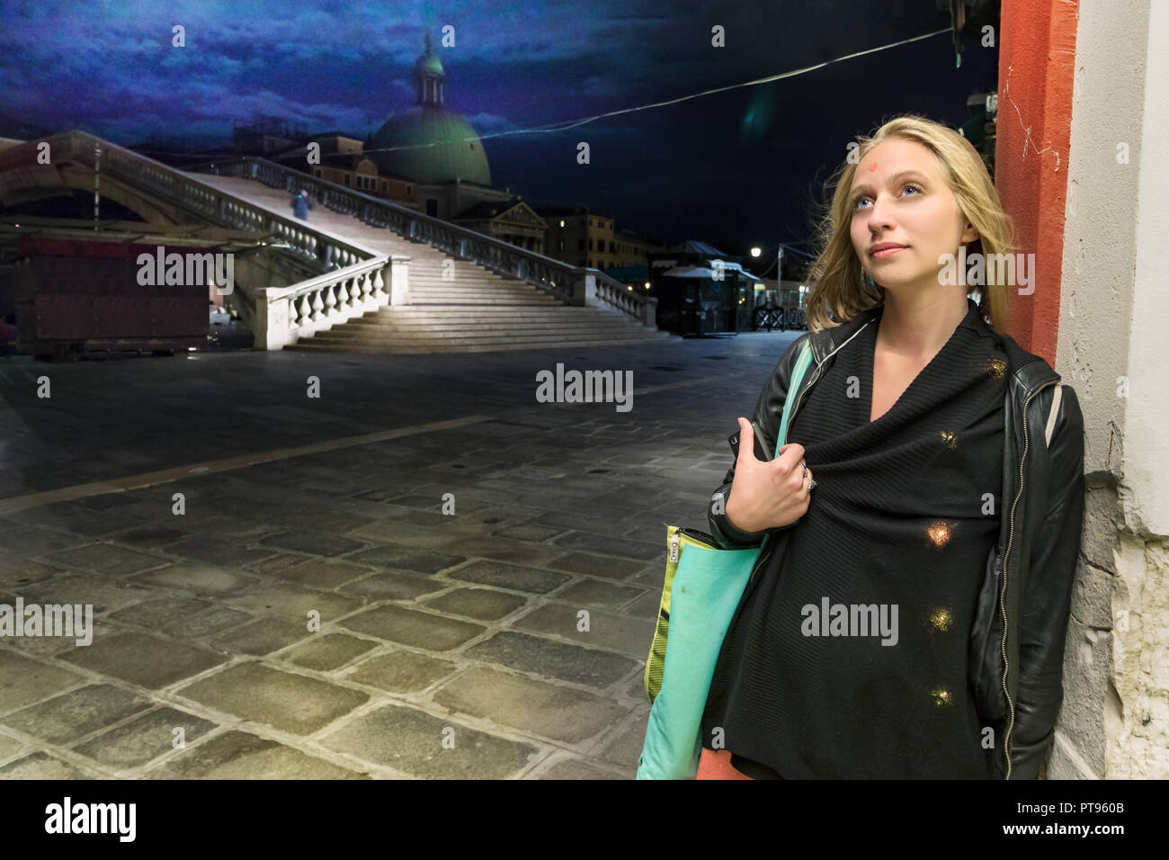 Venise, Italie - Septembre 26th, 2018 : Une jeune femme portant piercing dans le nez est à la pensée le ciel s'appuyant sur un mur de nuit à la ponte d Banque D'Images