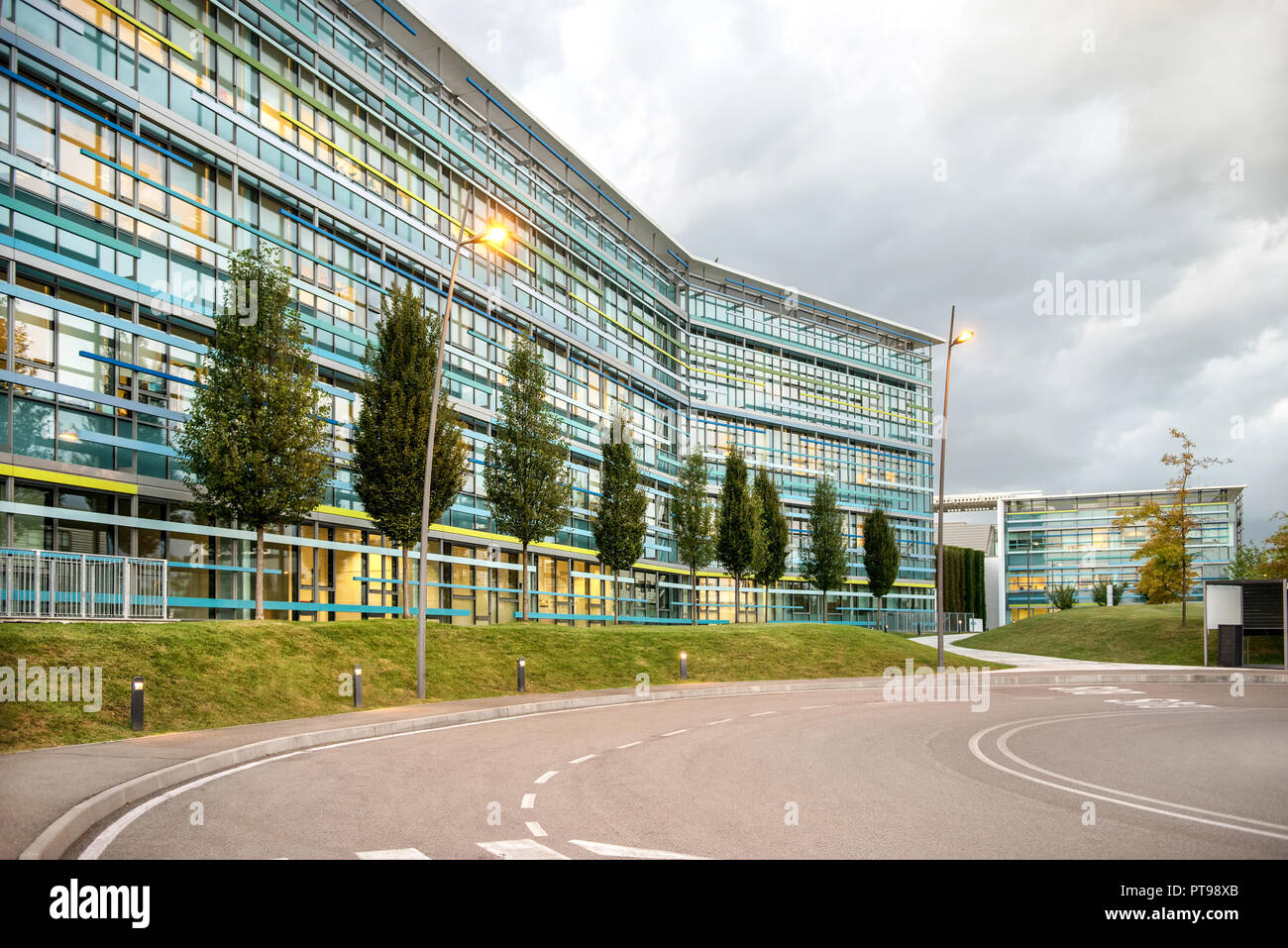 Route à l'extérieur immeuble de bureaux moderne complexe avec des fenêtres en verre bleu. Banque D'Images