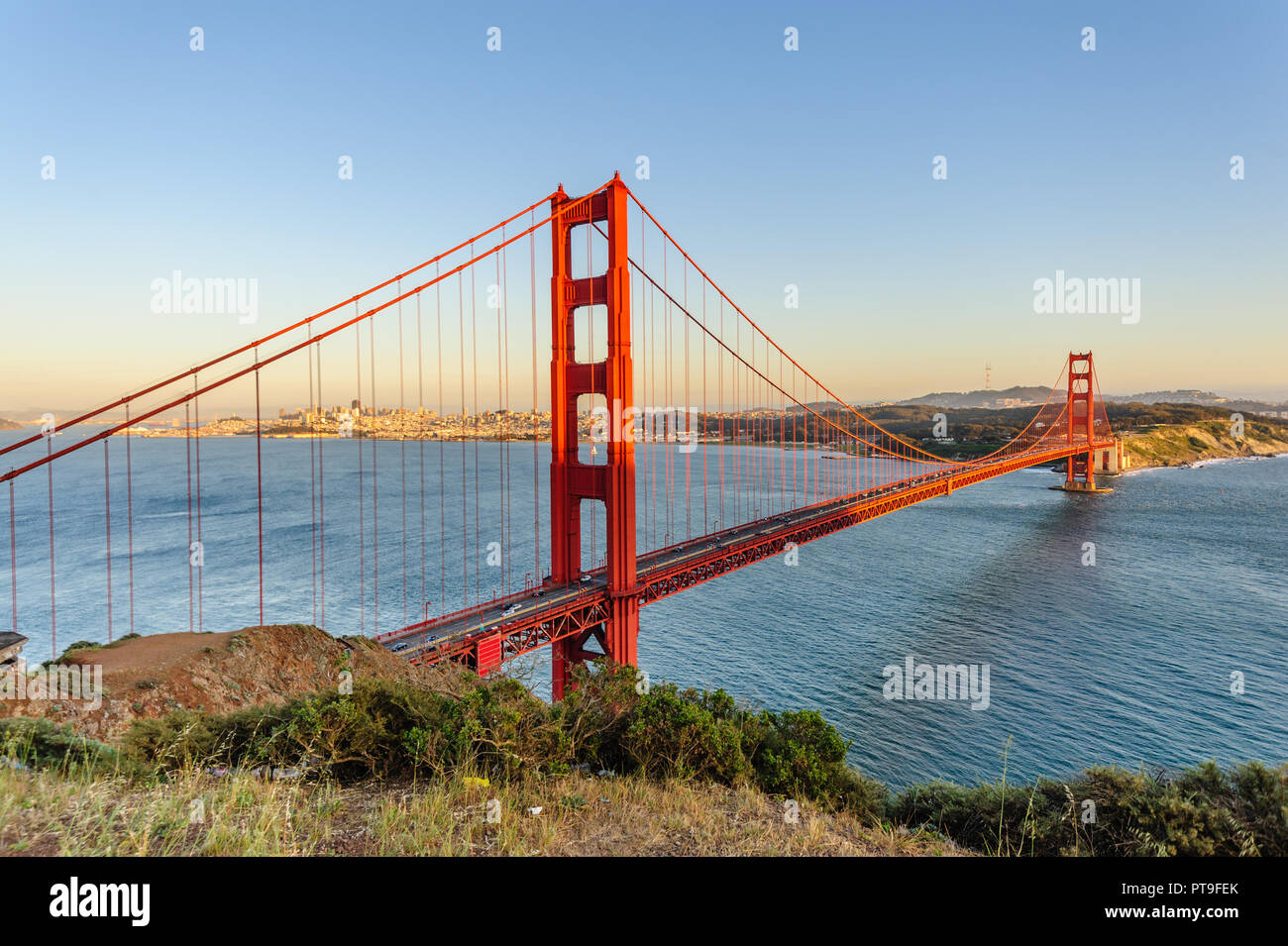 Le Golden Gate Bridge, avec le centre-ville de San Francisco et de San  Francisco Bay Area comme arrière-plan, au cours de l'heure d'or au coucher  du soleil. Image prise à partir de